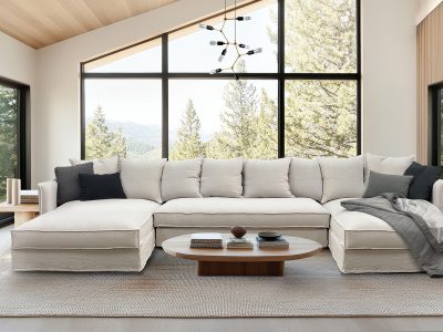 A light filled Scandinavian living room with cozy sofa and natural views